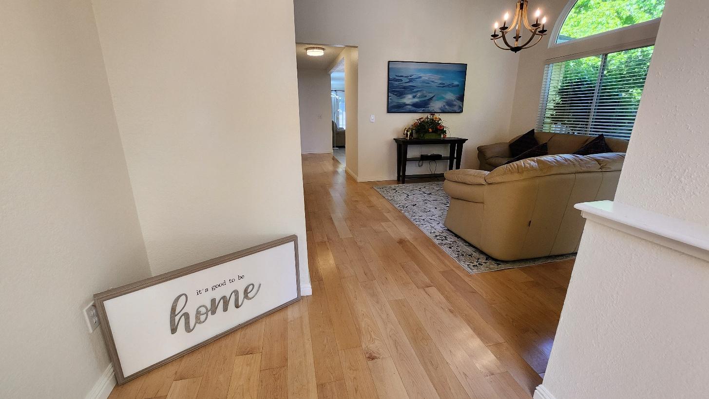 Hallway with an 'it's good to be home' sign opening into the living room